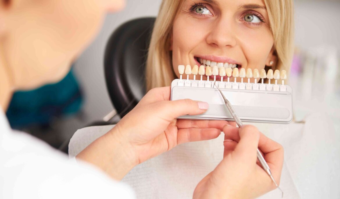 A dentist showing a patient various shades of teeth